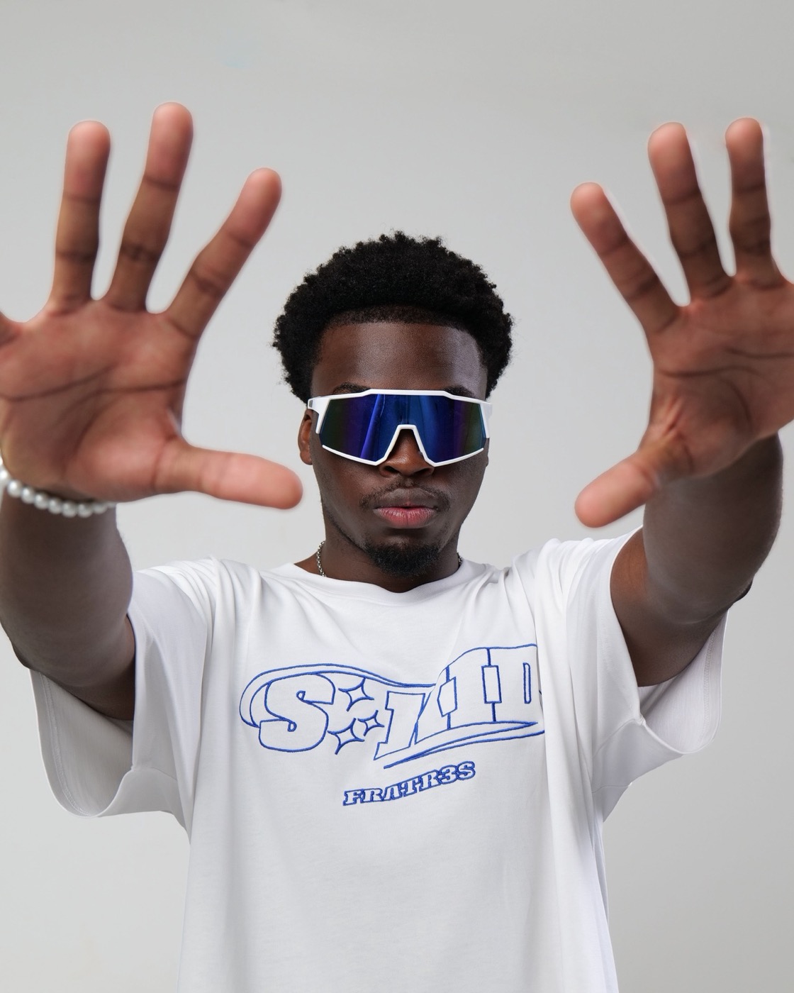 Model in sunglasses reaching toward the camera