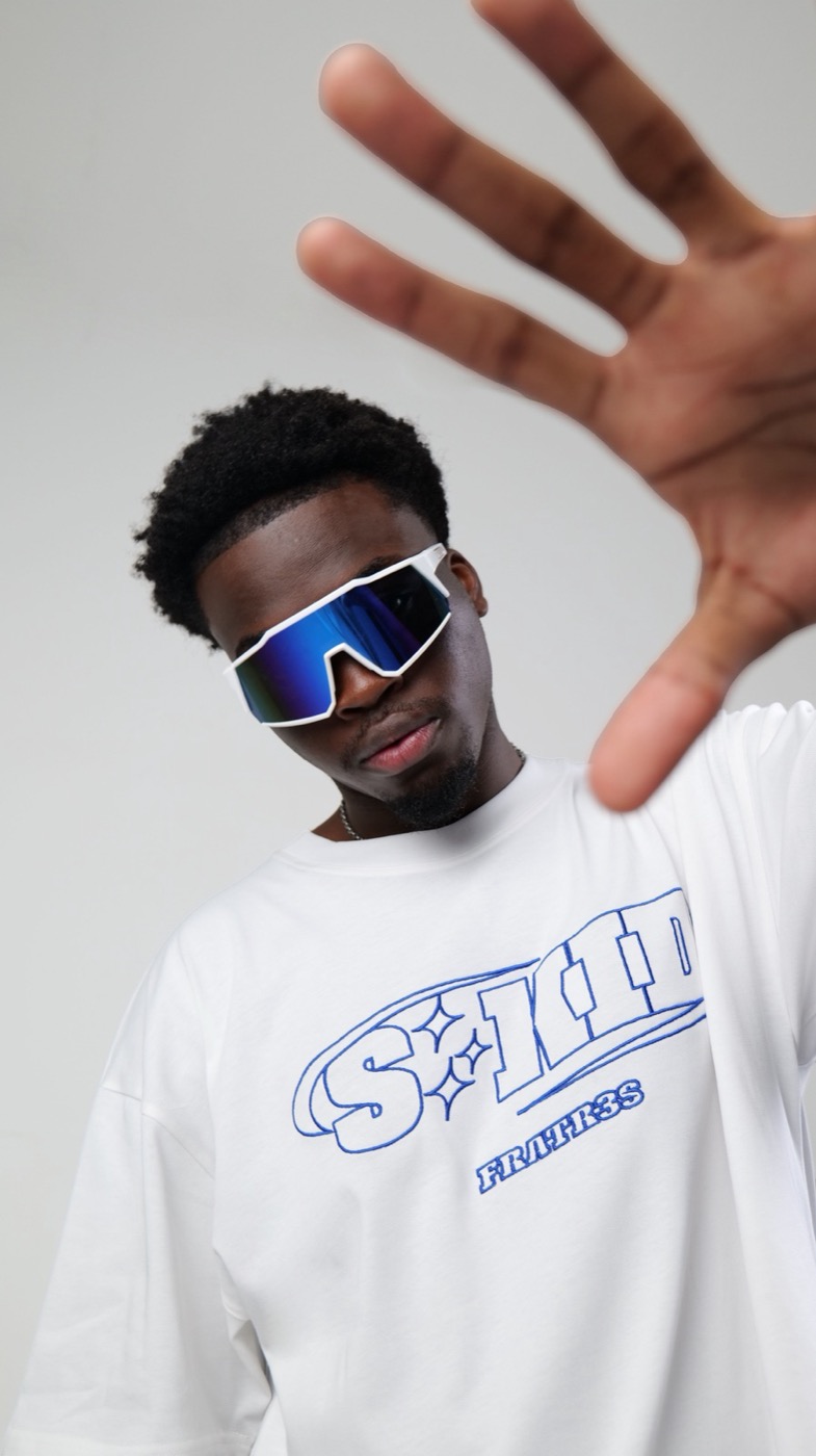 Model in sunglasses with one hand raised