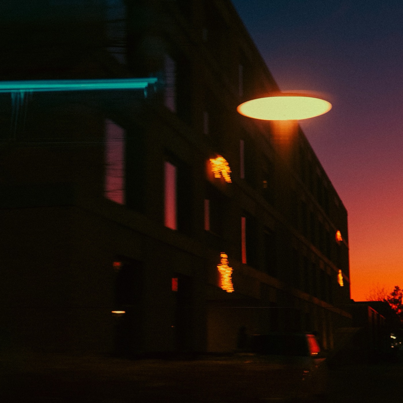 Street lamp glowing against an orange sky