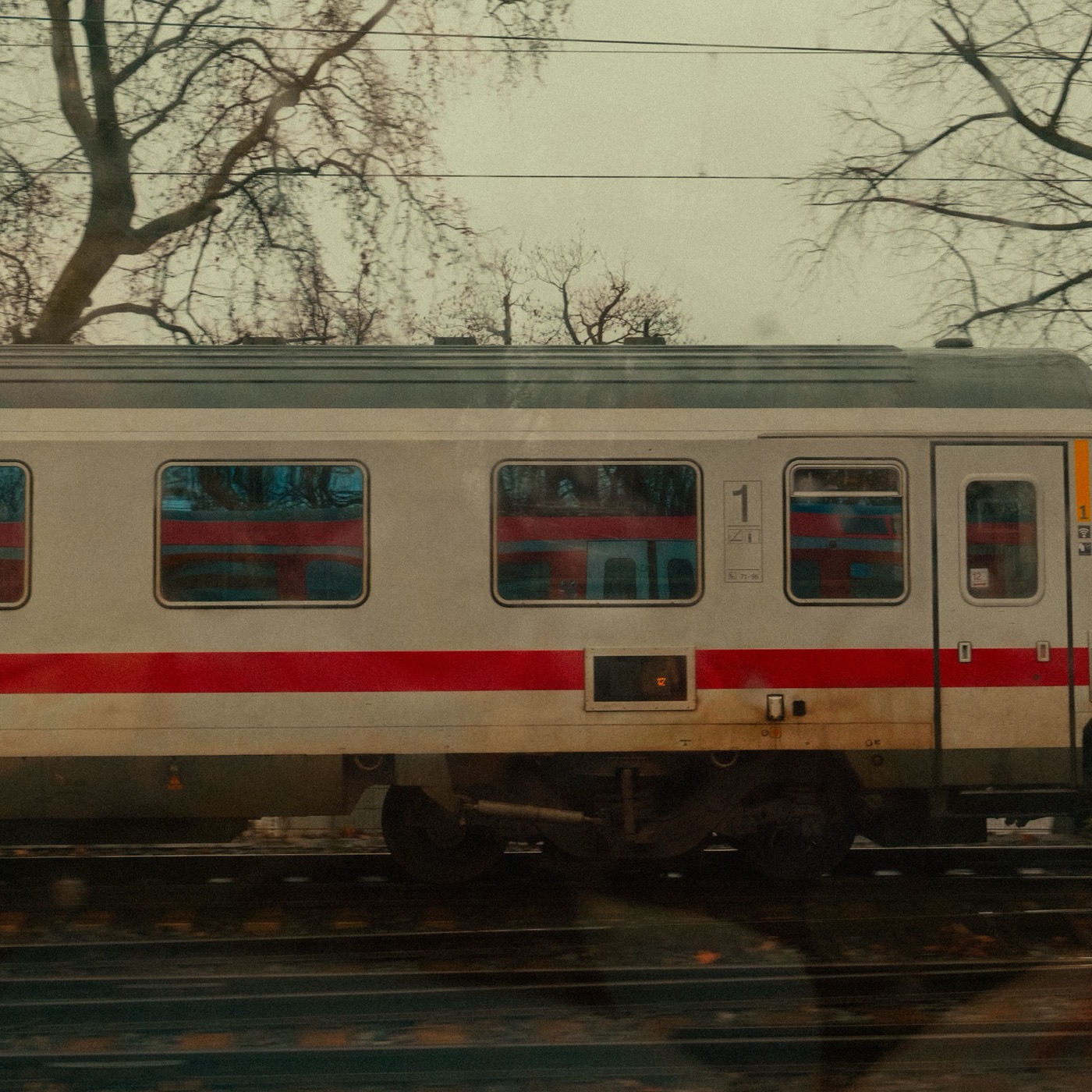 Passenger train passing bare trees