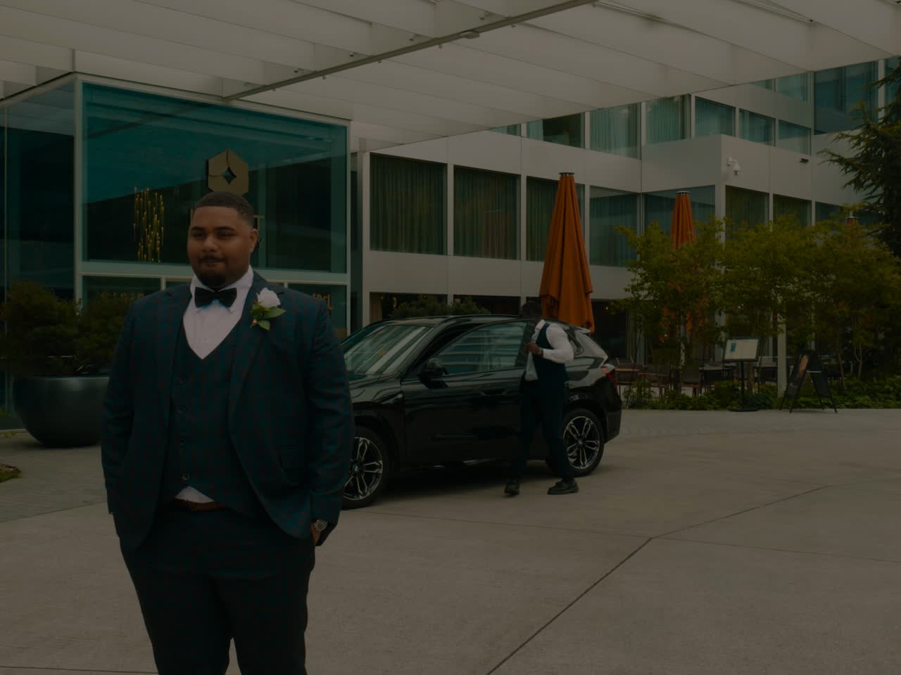 Groom in a dark suit waiting outside a hotel